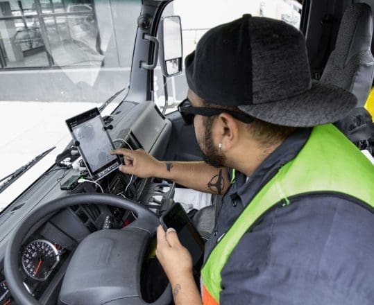 truck driver using tablet mounted on dashboard