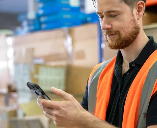 a warehouse worker checking item location with a mobile device